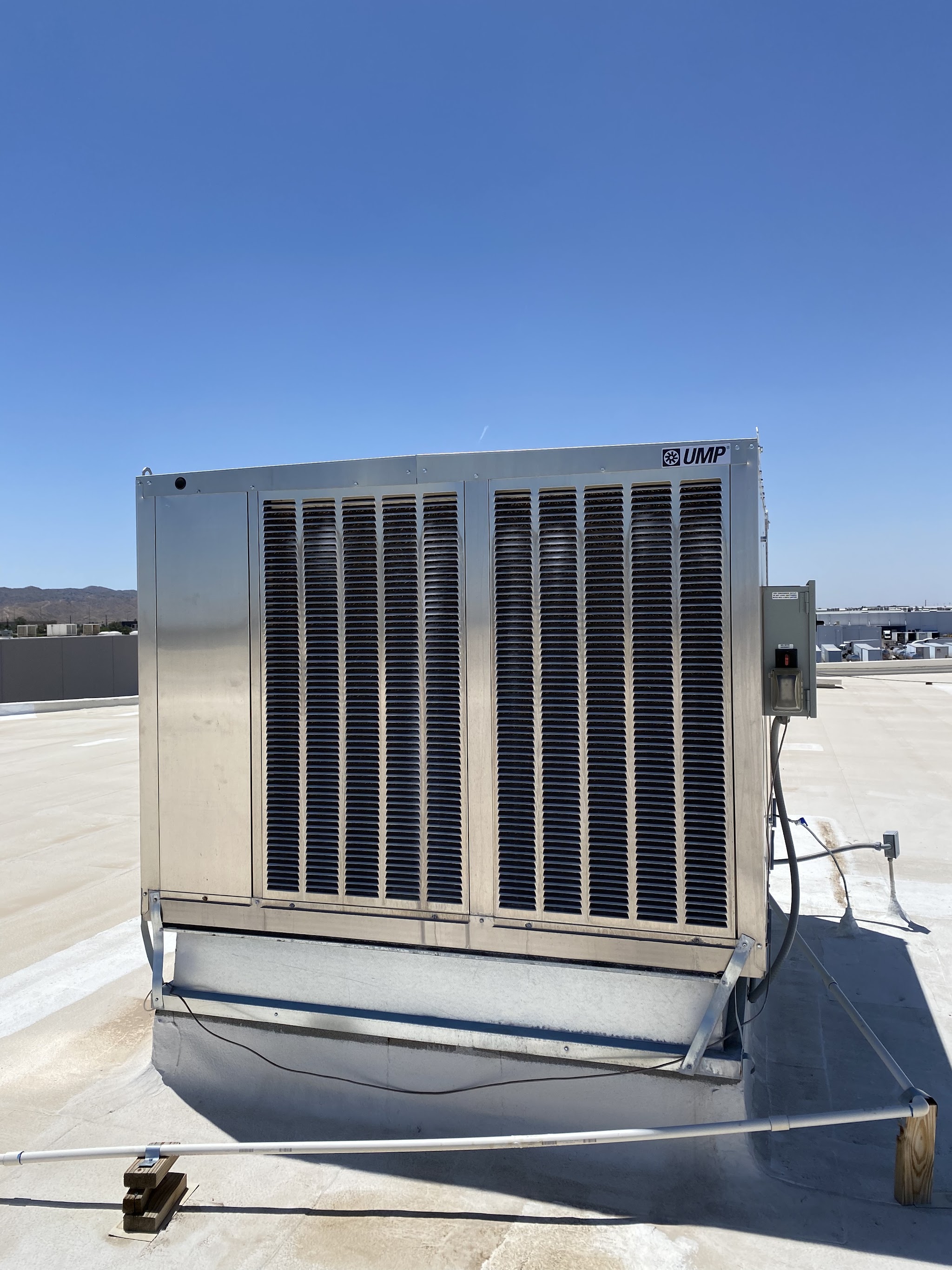 A large rooftop unit on a commercial flat roof with the Phoenix mountains behind
